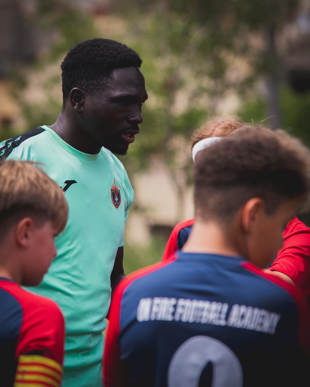 Cherif Badji con un alumno en el campo de la Penya Blaugrana de Cervelló